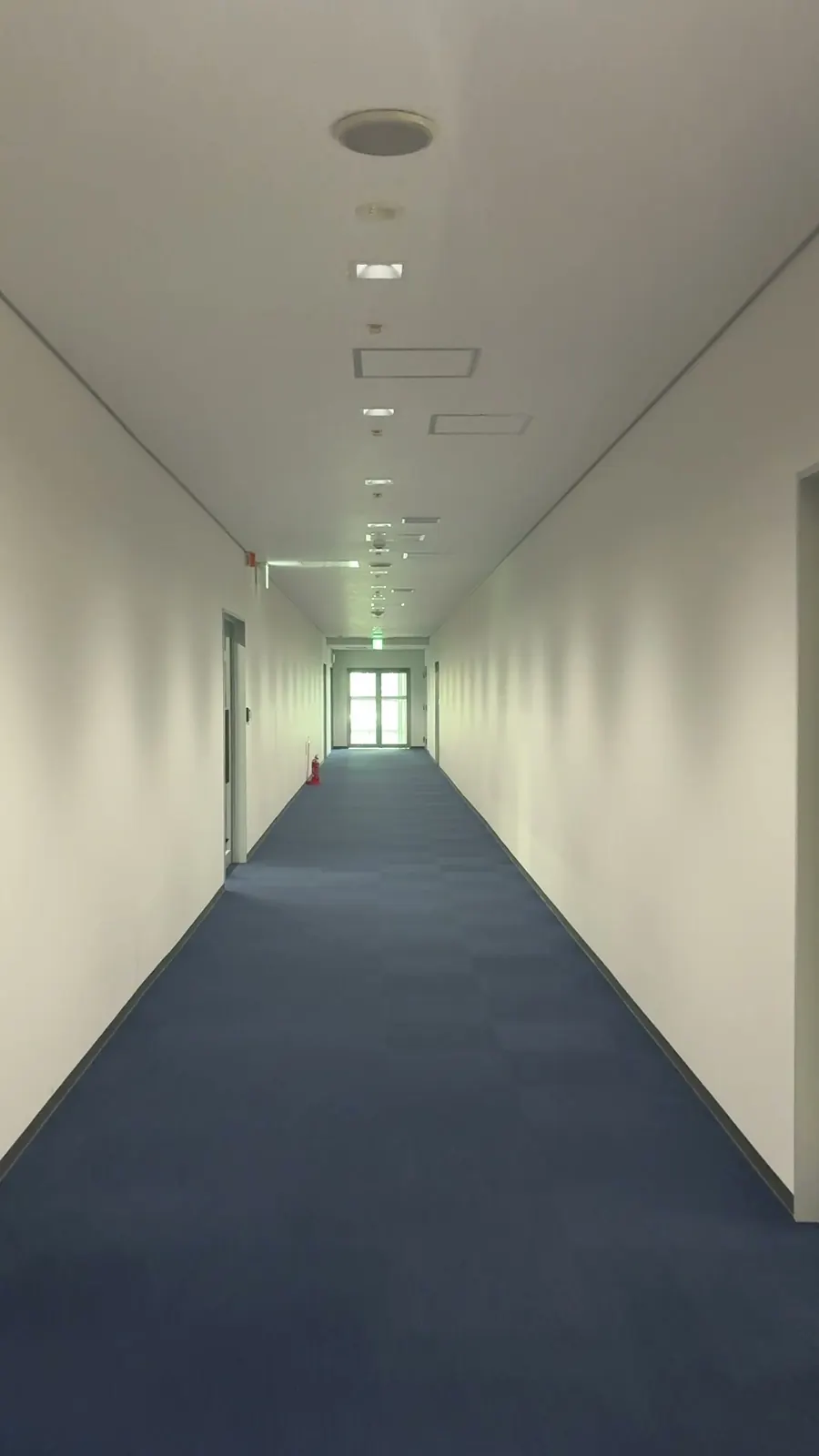 ATCの青い絨毯が続く通路。突き当たりの窓から光が入っています。